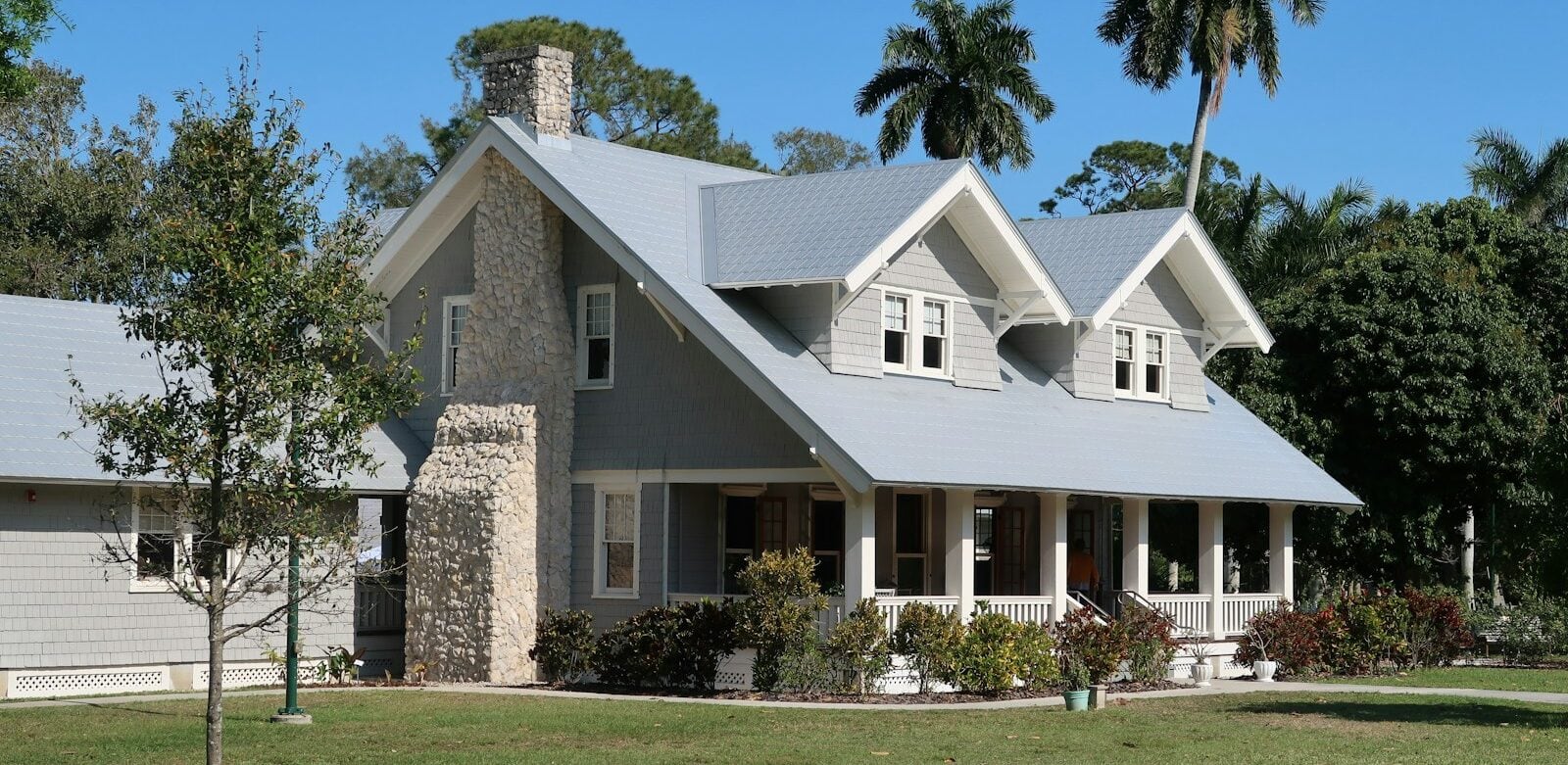 brown and white concrete house near green grass field during daytime