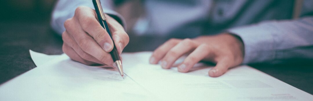 man writing on paper