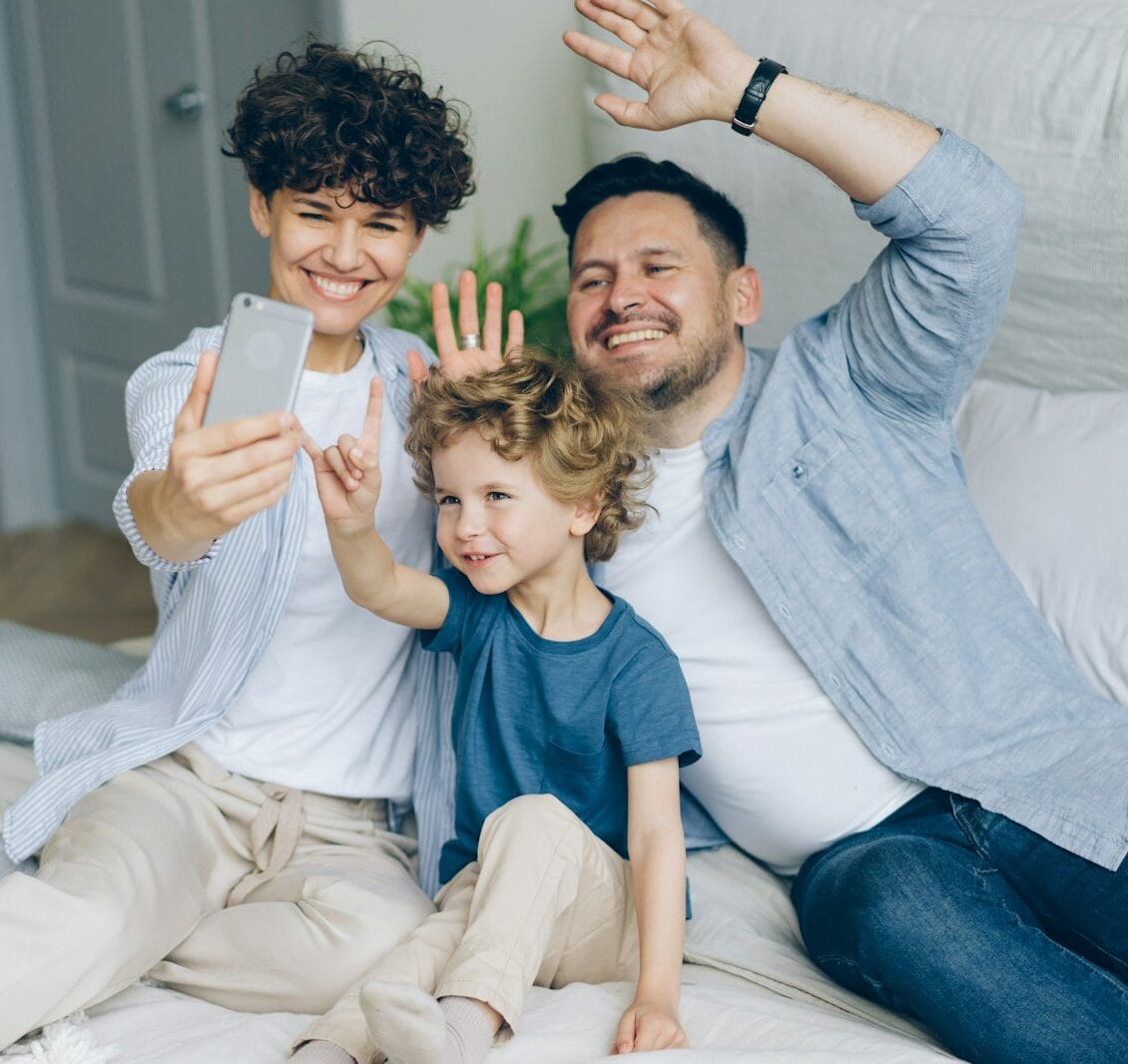 a man and two children sitting on a bed